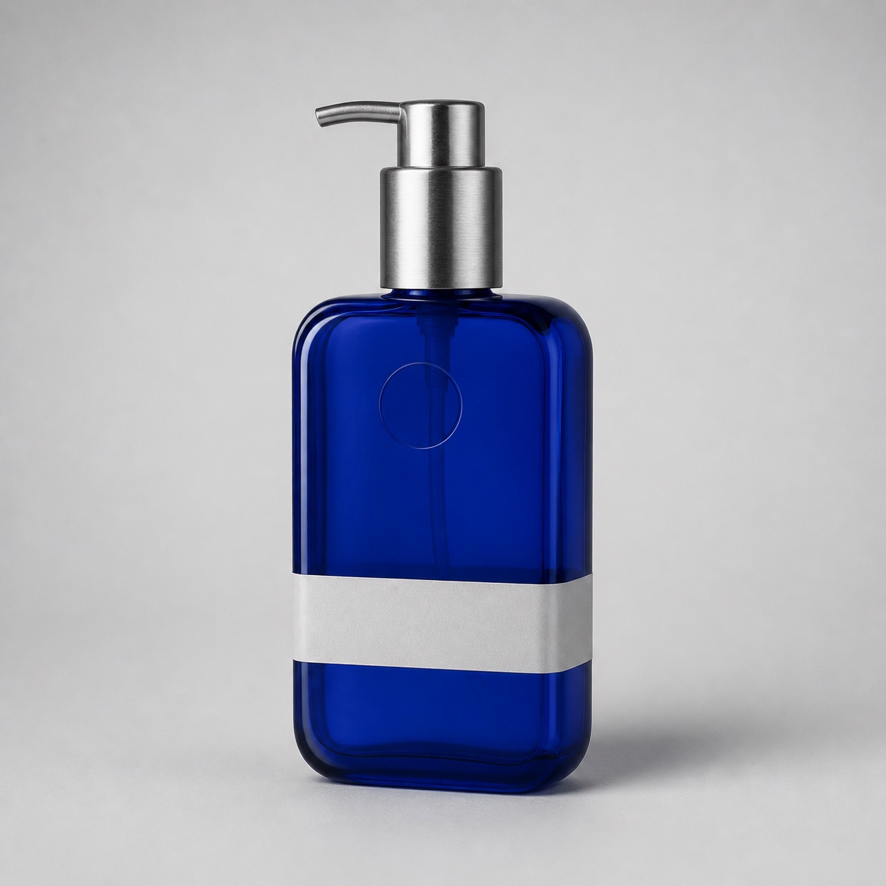 Unbranded cobalt blue glass pump bottle on a neutral studio background used as the authorized review source